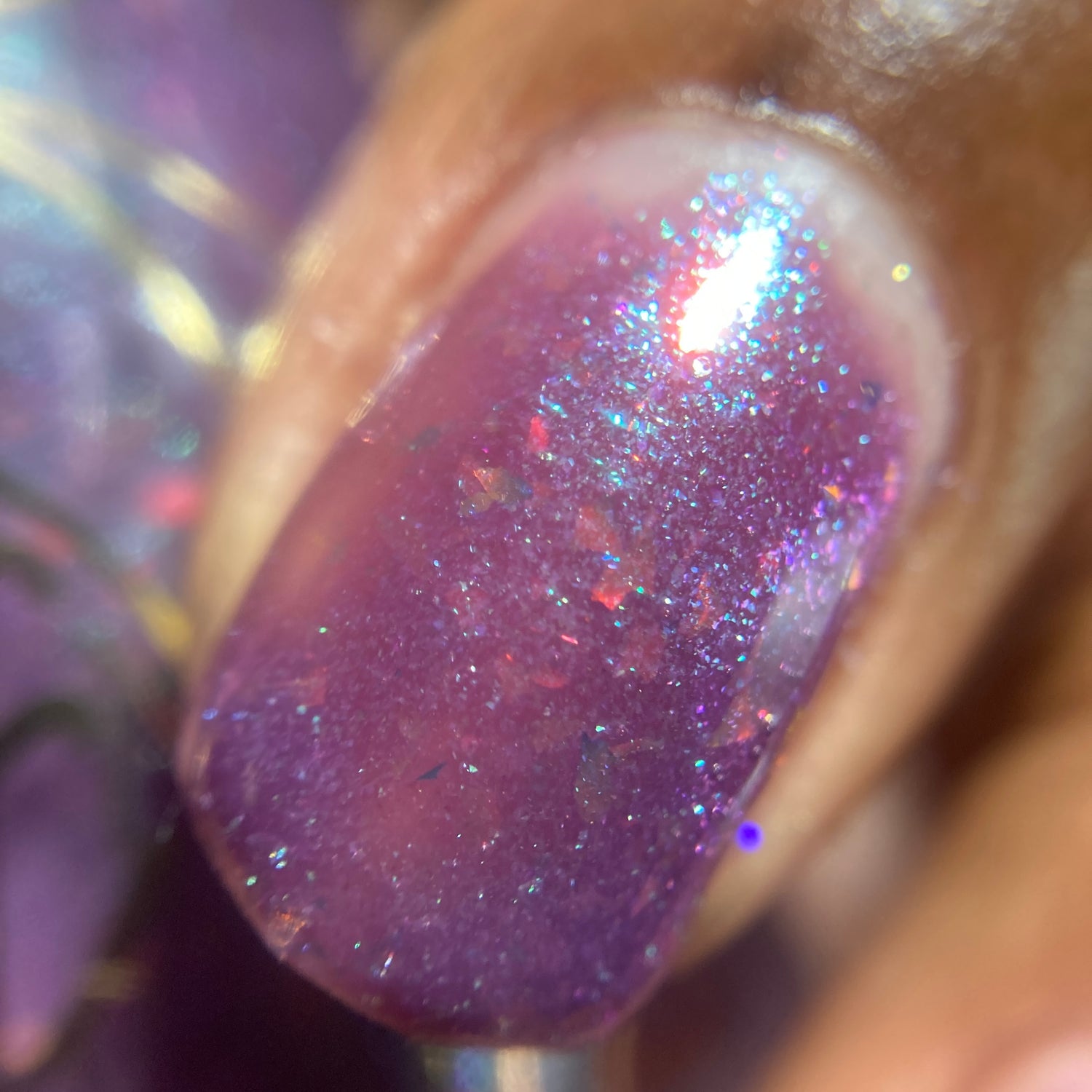 close up view of Clappin' Kathy applied with holographic flakes in purple base